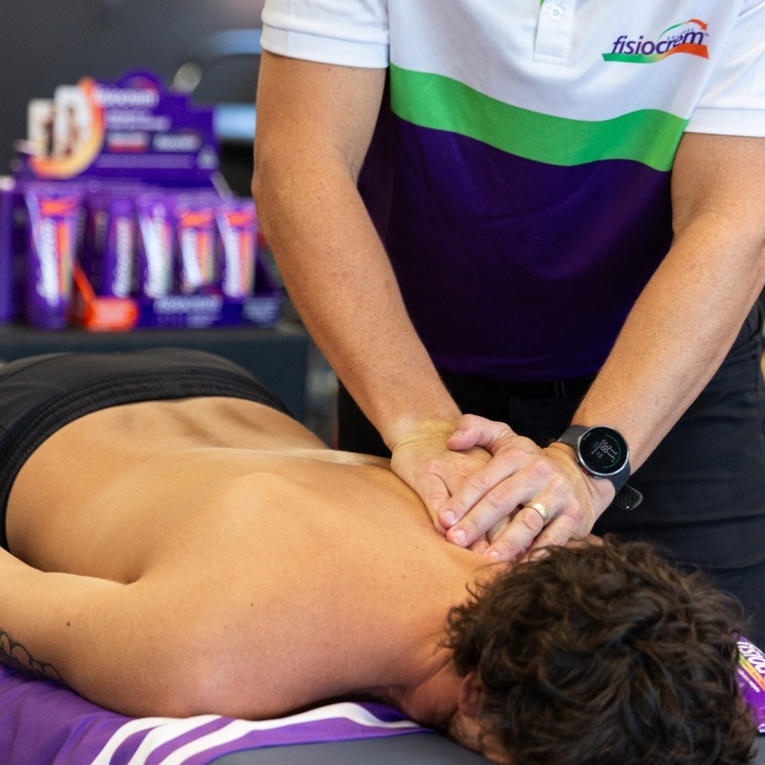 Close-up of a practitioner massaging a client's upper back.