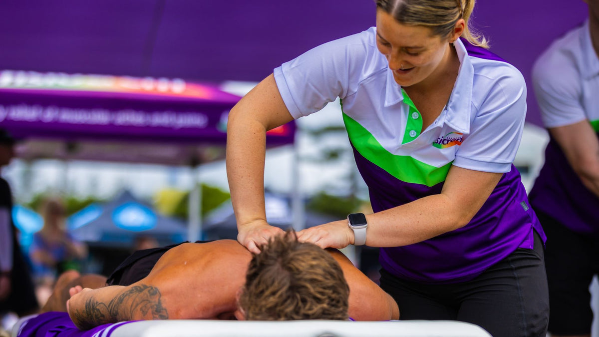 fisiocrem team member massaging a participant's upper back at an event.
