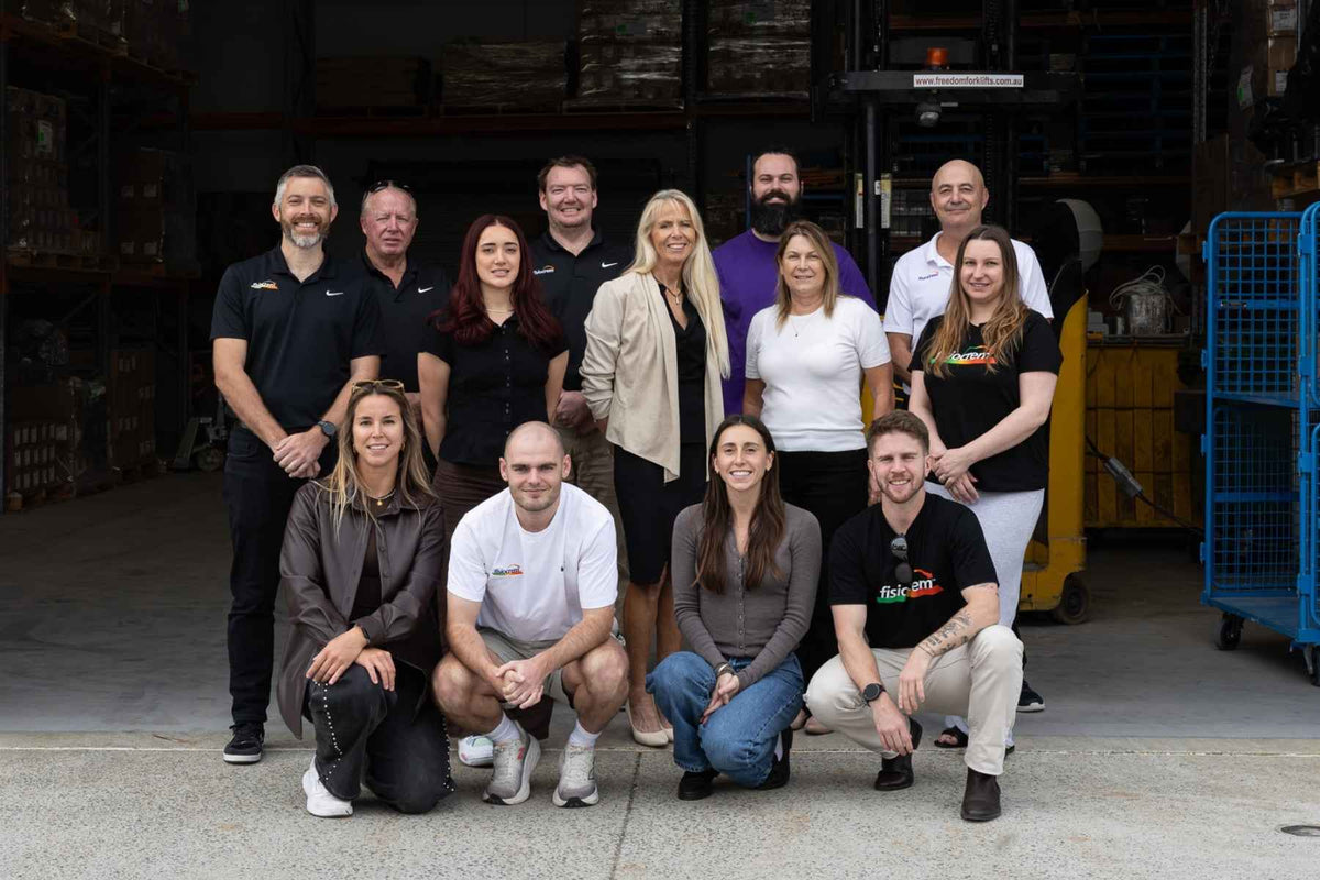 fisiocrem team posing together at a warehouse entrance.